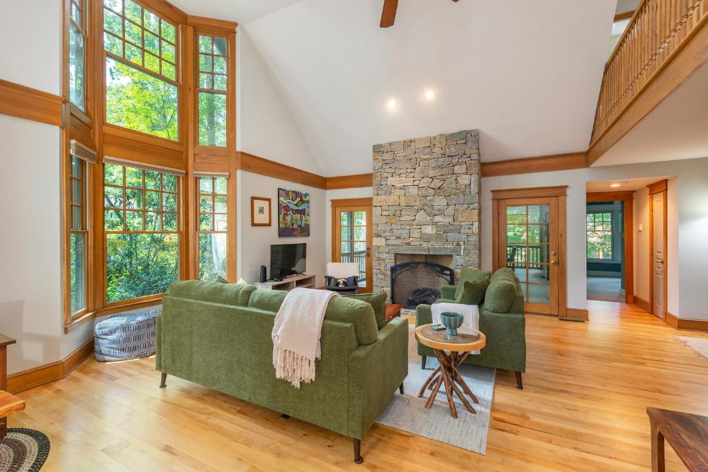 a living room with two couches and a stone fireplace at The Wander Inn in Black Mountain