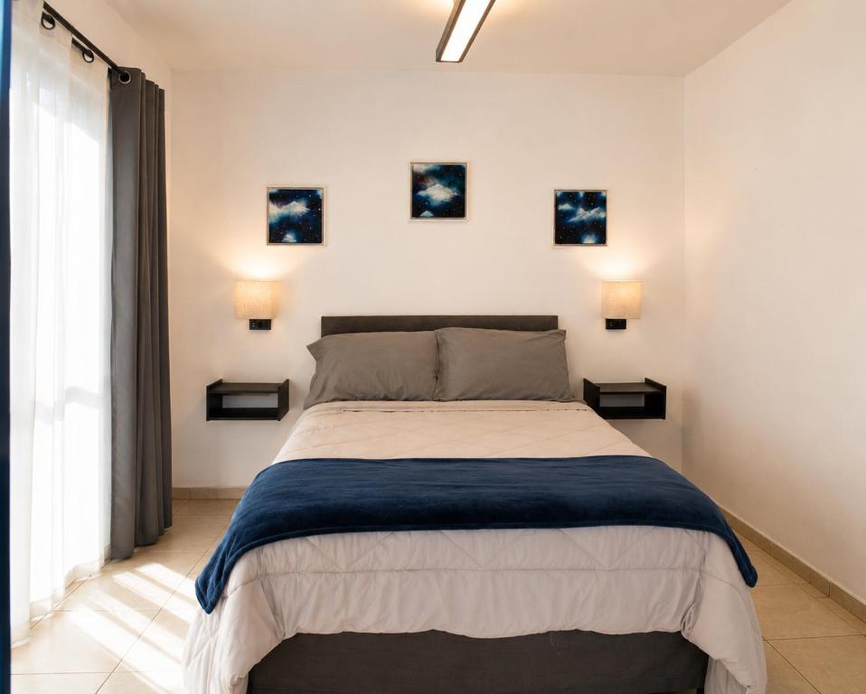 a bedroom with a bed with three pictures on the wall at Suite en el corazón de Arandas in Arandas