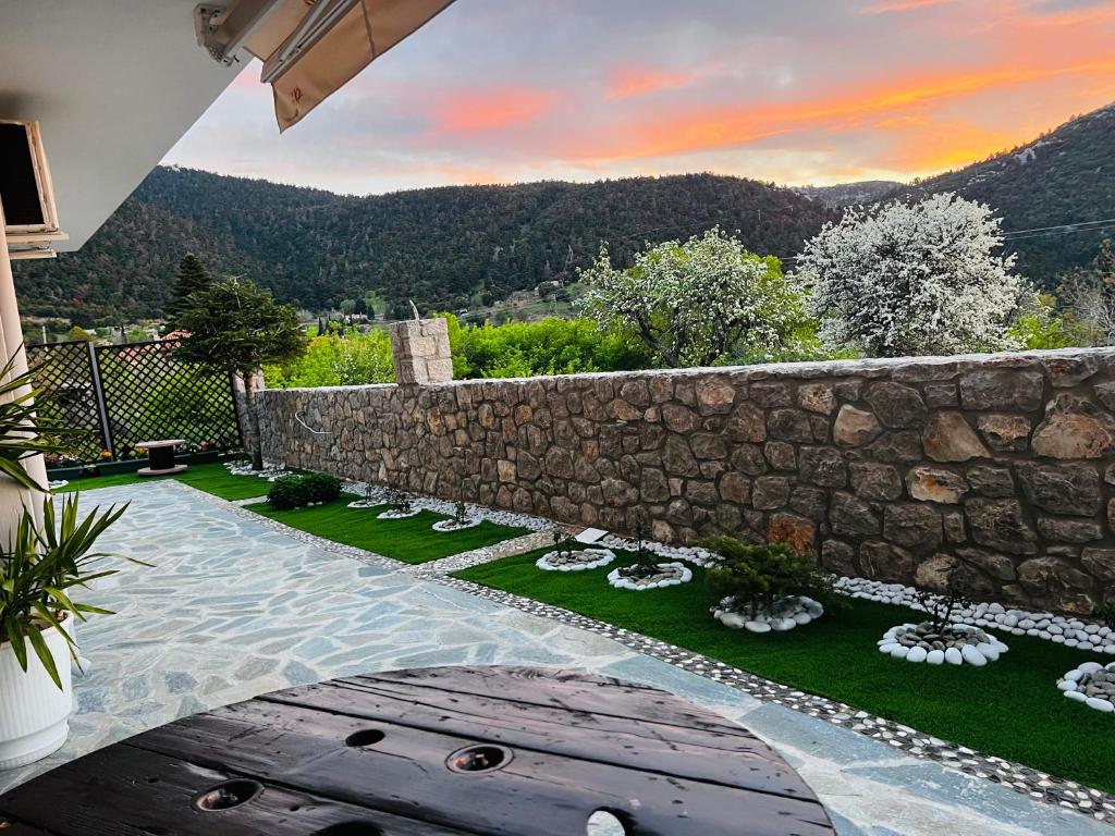 a backyard with a stone retaining wall and a garden at Quiet Mountain View Retreat Helicon, Kyriaki in Kiriákion