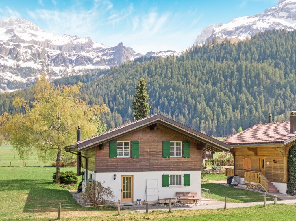 a house in a field with mountains in the background at Sonniges Chalet mit fantastischem Bergblick in Lenk