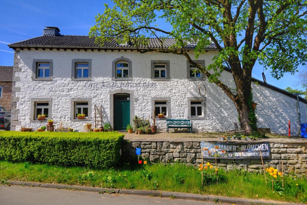 a white stone house with a green door at Gut Kalkhäuschen, ein Ort mit Geschichte in Aachen
