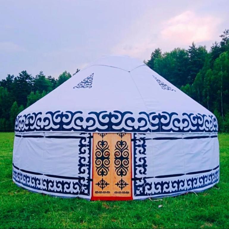 a large white tent sitting in the grass at Юрта in Karakol