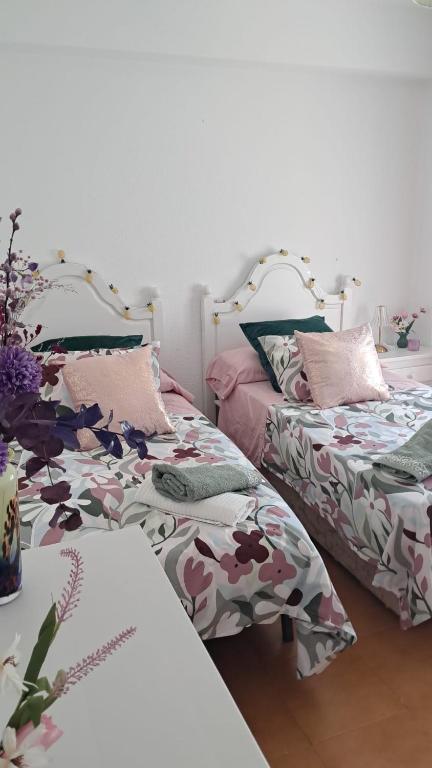 two beds sitting next to each other in a room at Apartamento MILA centro in Comillas
