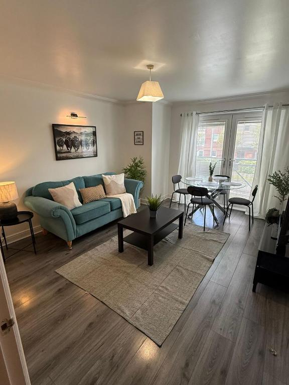 a living room with a couch and a table at Modern 2-Bed Near Braehead in Renfrew