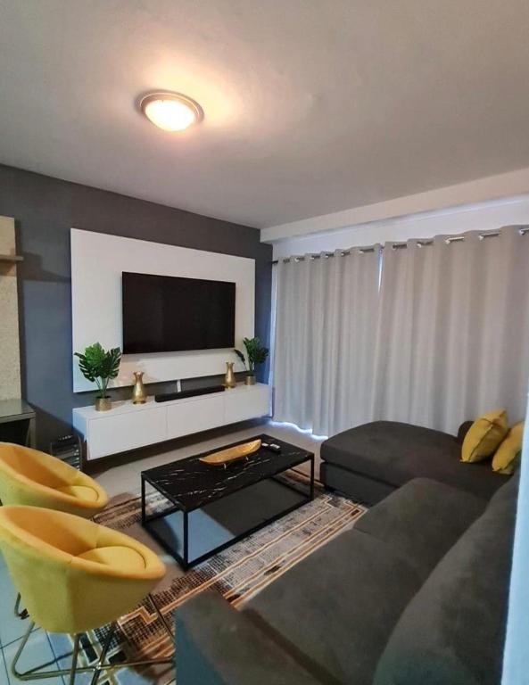 a living room with a couch and a tv at Modern 2 Bed 1 Bath Apt With Complex Pool in Johannesburg