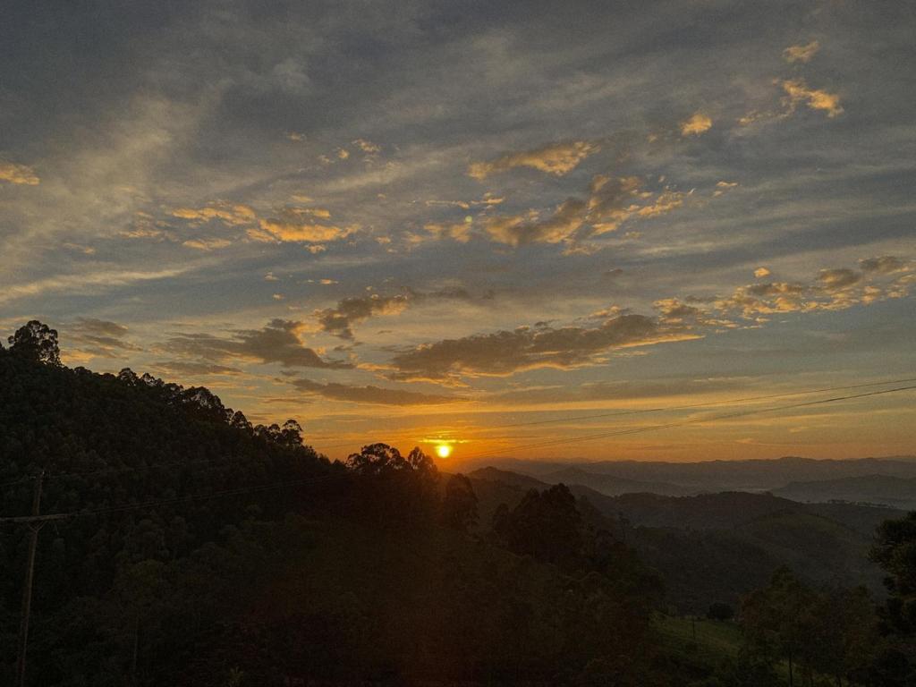 a sunset in the mountains with the sun setting at Casa Aroni - 1300m altitude in Extrema
