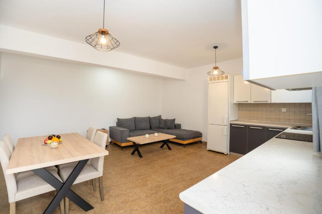 a kitchen and living room with a table and a couch at Blue Veranda Apartment in Pera Gyalos