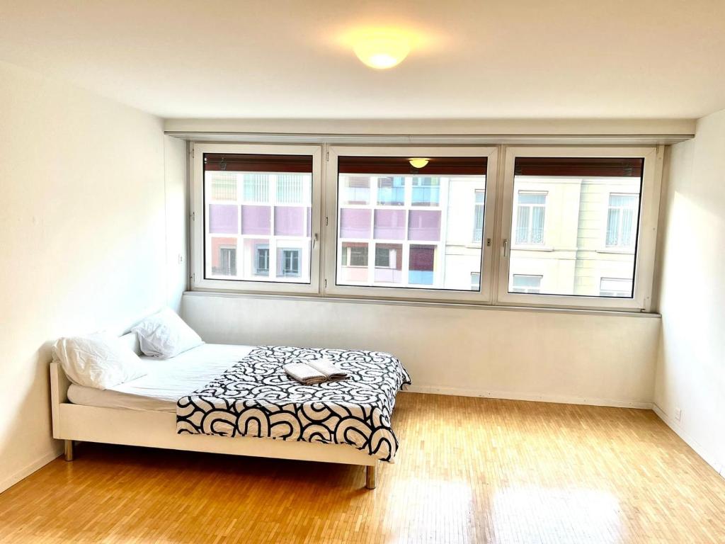 a bedroom with a bed and two windows at Downtown Flats - Lake Lucerne in Lucerne