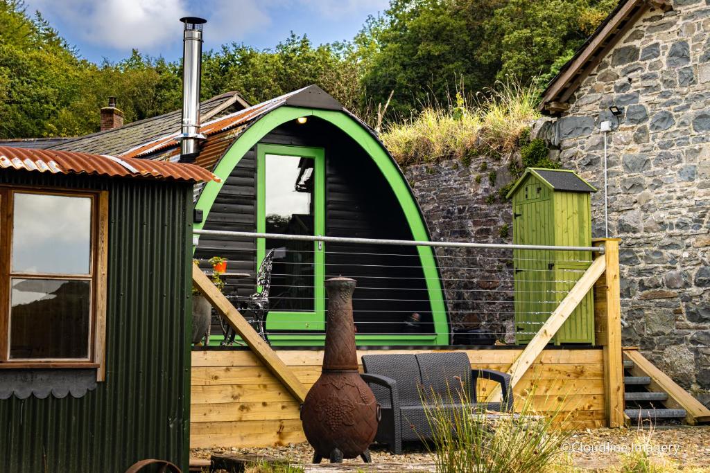 a green house with a vase next to a building at Scenic Pet Friendly Pod in Talybont Aberystwyth in Aberystwyth