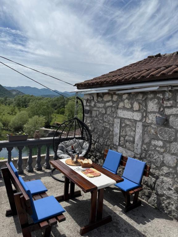 a table and chairs on a patio with a view at Lake Escape Dodoši in Dodoši