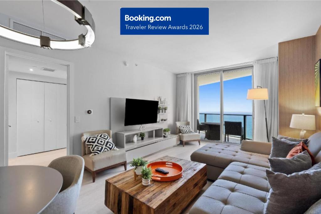 a living room with a couch and a table at PRICE REDUCED DUE TO FLOOR COSMETIC DAMAGE - Picturesque Beachfront Condo - LOVELY 2BD and 2BA APT WITH DIRECT OCEAN VIEW in Hollywood