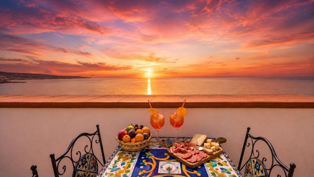 a table with a bowl of fruit on a balcony with a sunset at Apartment Casa Beatrice in Pizzo