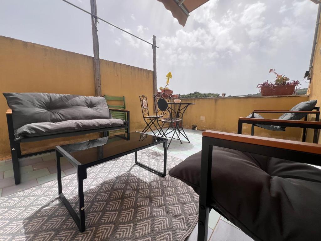 a balcony with a couch and a table on a patio at La Rosa dei Monti Iblei in Ferla