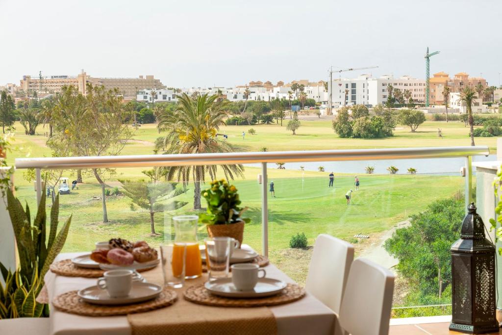 a table with a view of a golf course at Apto Oasis Playa & Golf Almerimar in Almerimar