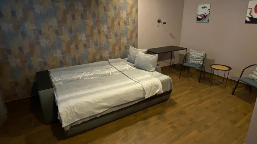 a bedroom with a bed and a table and chairs at Квартира в центре города in Uman