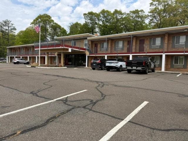 a parking lot in front of a building with cars at Wethersfield Motel in Wethersfield