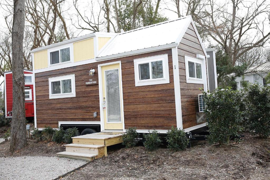a tiny house is sitting in a yard at River and Twine in Rocky Mount