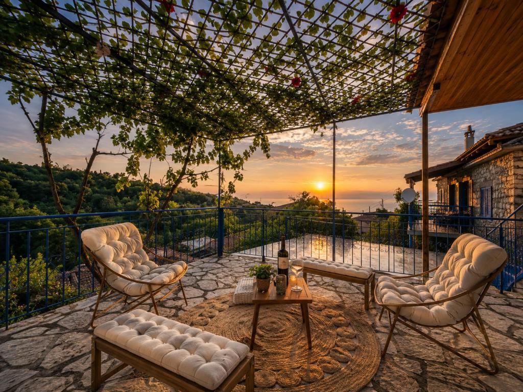 two chairs and a table on a balcony with a sunset at Belle Elle Villa in Drymon