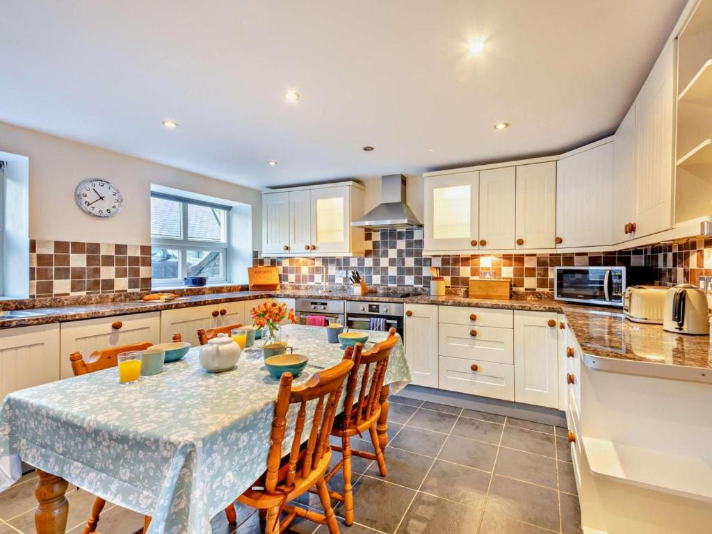 a kitchen with a table and chairs and a kitchen with white cabinets at 4 Bed in Bishop Auckland oc-93527 in Wear Head
