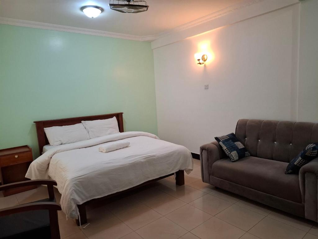 a bedroom with a bed and a couch at G4 homez in Morogoro