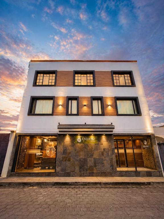 a white building with windows on the side of it at Hotel Endamo in Latacunga
