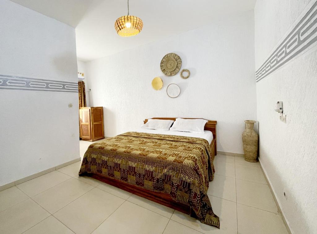 a bedroom with a bed and a clock on the wall at Hôtel villa blanca in Lomé