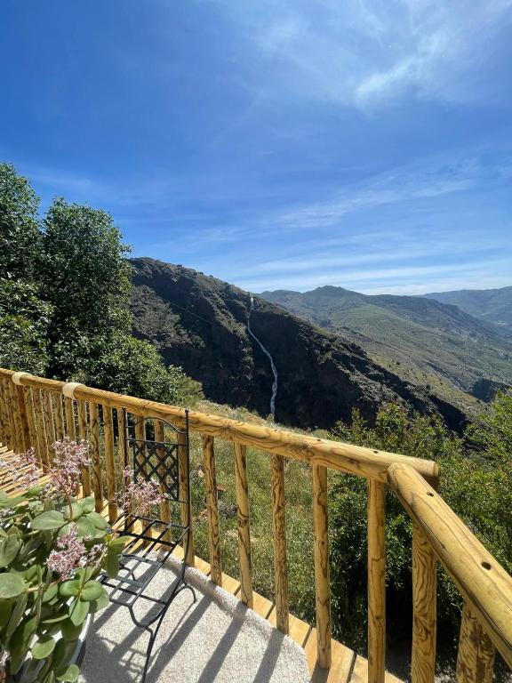 a wooden balcony with a view of a valley at Casa Walhalla & Cortijo El Páramo in Pampaneira