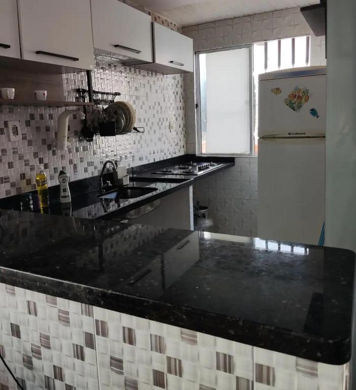a kitchen with a black counter top and a refrigerator at Bruno in São José de Ribamar