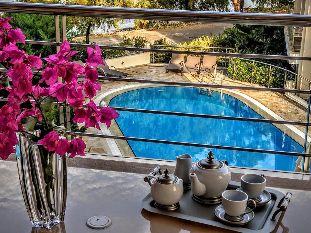 a vase of flowers sitting on a table next to a pool at Nefeli Duplex Apartment in Karavomylos