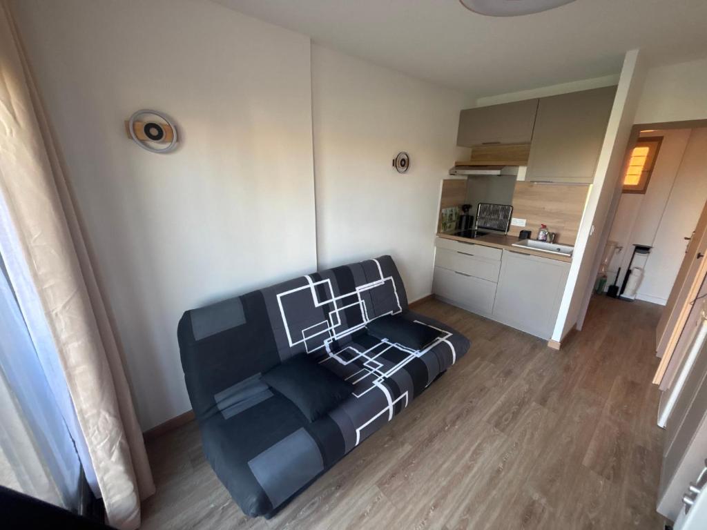 a living room with a couch and a kitchen at 423 Résidence Aphrodite naturiste in Leucate-Plage