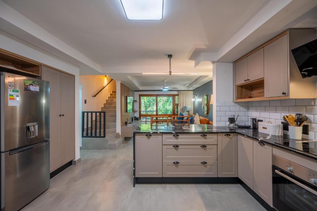 a kitchen with white cabinets and stainless steel appliances at Kruger Park Lodge - Modern Unit 225B in Hazyview
