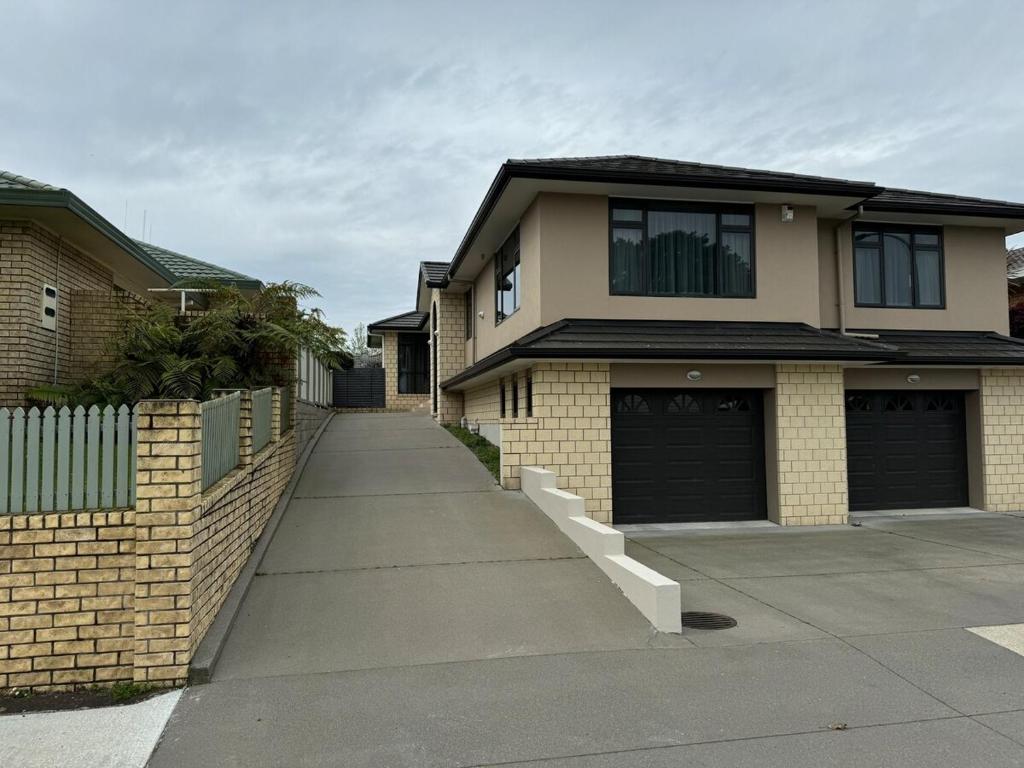 a house with two garage doors and a driveway at Duke St Townhouse in Cambridge