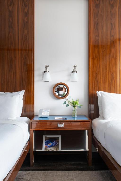 ein Zimmer mit zwei Betten und einem Tisch dazwischen in der Unterkunft Hotel Hugo in New York