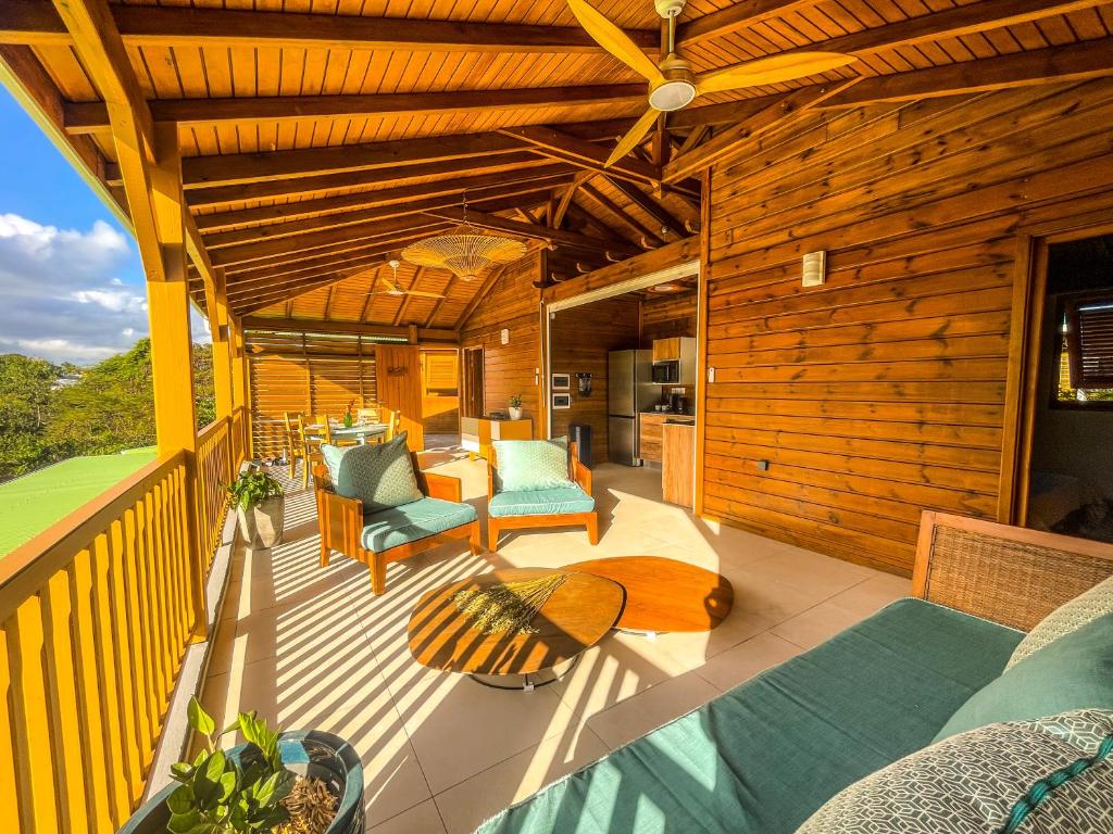 a deck with chairs and tables on a house at Bohème Chic, 2 Suites, Terrasse XXL in Le Gosier