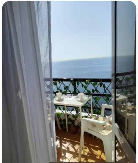 a balcony with a table and a view of the ocean at Appartement vue mer à Fnideq in Fnidek