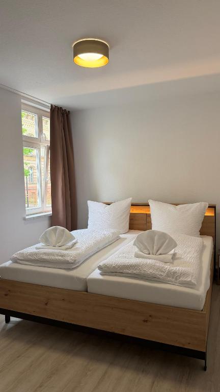 a bed with white sheets and pillows in a room at FeWo Augusta in Neustrelitz