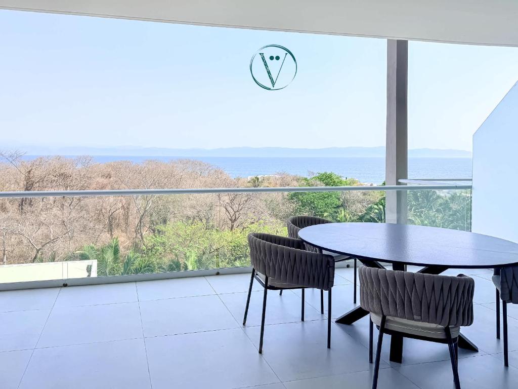 a table and chairs in a room with a view of the ocean at Endless Ocean Views Luxury Bolongo Escape in Higuera Blanca