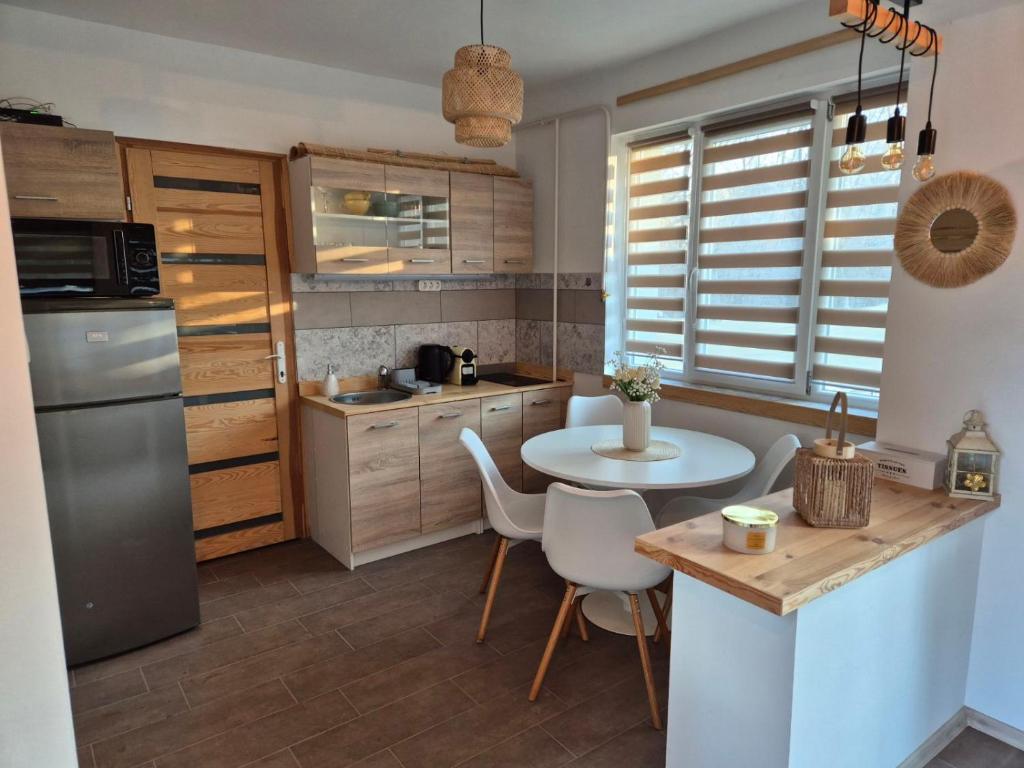 a kitchen with a table and a small table with chairs at Balatoni Horizont Vendégház in Balatonakarattya