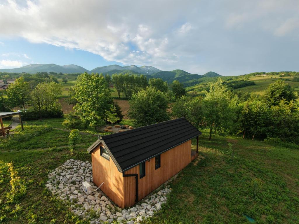 a small cabin with a black roof in a field at Dushka Mountain Cabin in Belec
