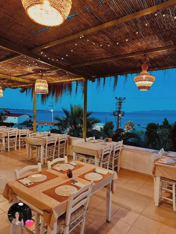 a restaurant with tables and chairs and a view of the ocean at Ekin Assos in Sokakagzi