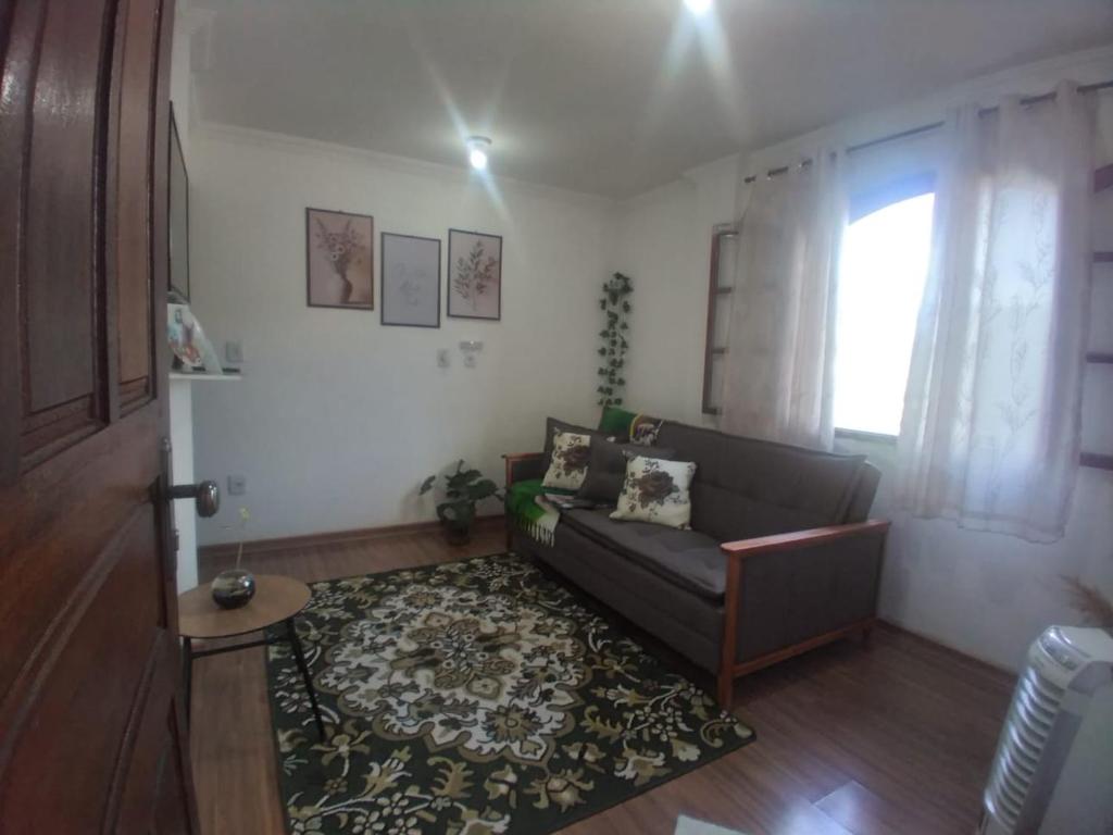 a living room with a couch and a rug at Maxi conforto e vista para o Itacolomi in Ouro Preto