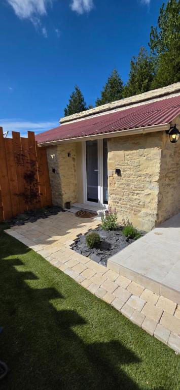 a brick house with a door and a grass yard at Studio Mazalys-Entre Mer et Campagne in Crépon