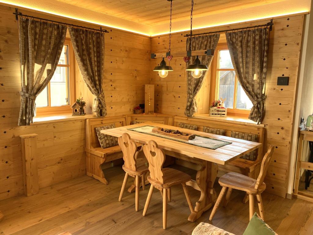 a dining room with a wooden table and chairs at My Sweet Home in the Dolomites - appartamento "Ai Vòlti" in Cavalese