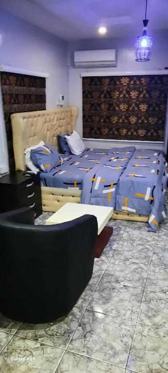 a bedroom with two beds and a couch in it at Kembod hotel & suite in Ikeja