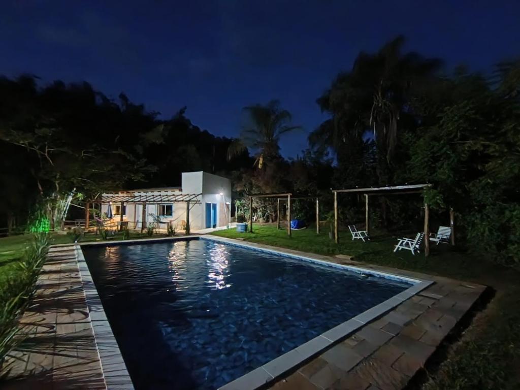 a pool in the backyard of a house at night at Villa Dona Jaca - Cabana 01 in Socorro