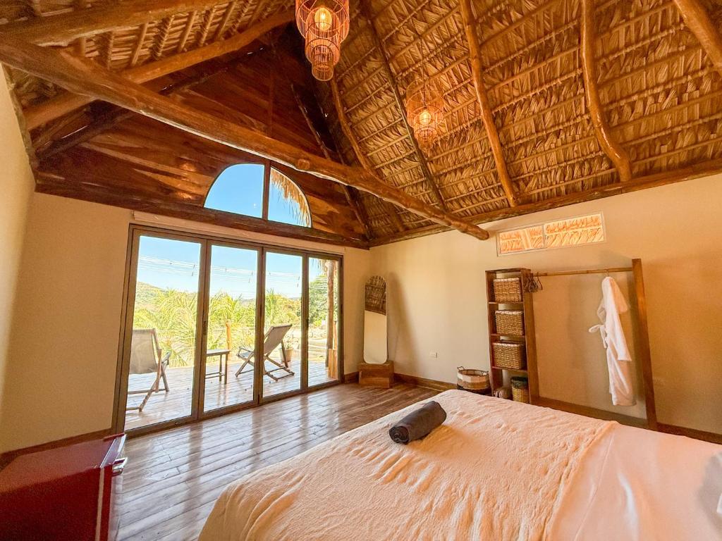 a bedroom with a bed and a large window at Seúl Haus in El Sunzal