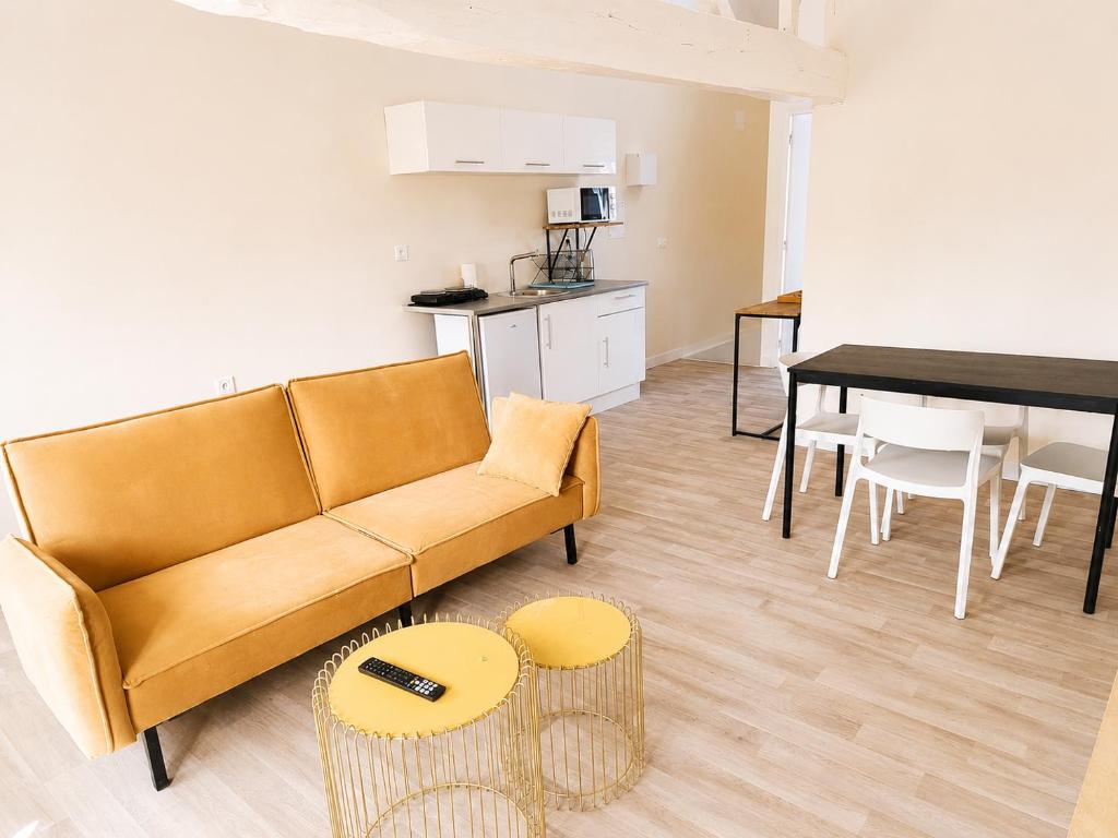 a living room with a couch and a table at Loft lumineux & cosy sous les toits in Roubaix