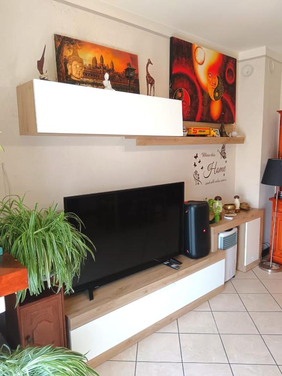 a living room with a flat screen tv on a wall at Vin's Apartment in Adro