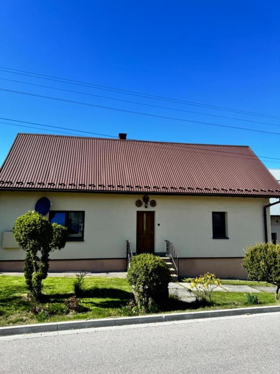 a small white house with a red roof at Domek u Krzyśka in Słopnice