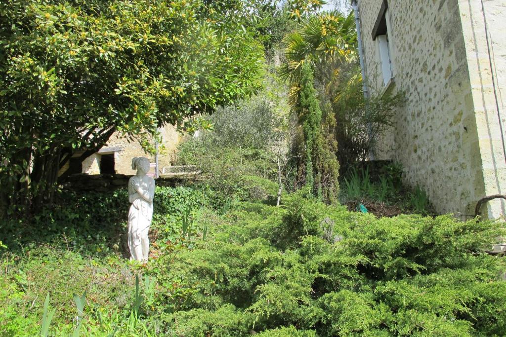 a garden with a statue in the grass at Songbird Sanctuary in Civray-de-Touraine